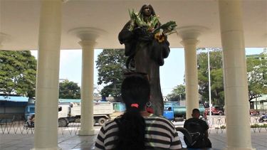 Una devota ante la escultura de La Virgen del Camino.