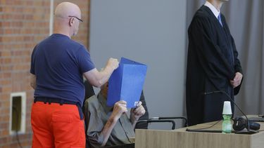 El acusado, Josef S., se cubre la cara al sentarse en un tribunal en Brandenburgo, Alemania, el 28 de junio de 2022.&nbsp;