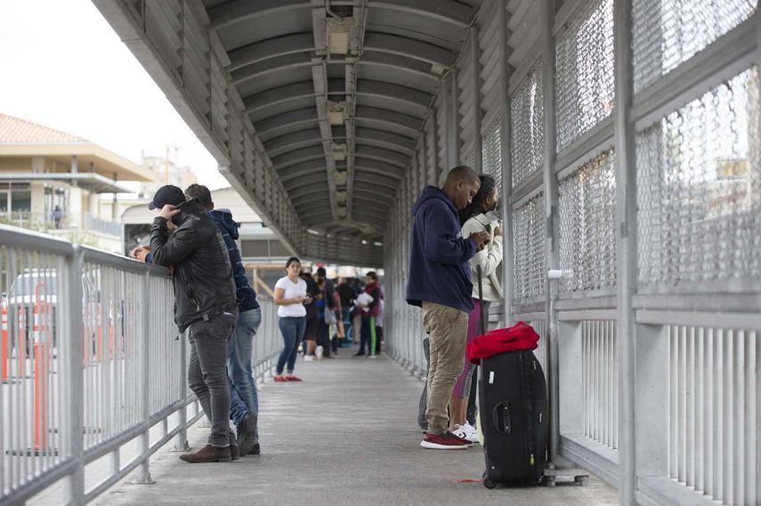 Un grupo de cubanos es visto en el paso fronterizo de Nuevo Laredo, México, un día después de la derogación de la política migratoria pies secos/pies mojados por parte de la administración Obama.