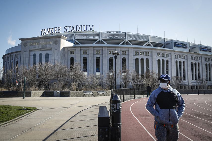 Un individuo con un mascarilla hace ejercicio camina cerca del Yankee Stadium, el jueves 26 de marzo de 2020.