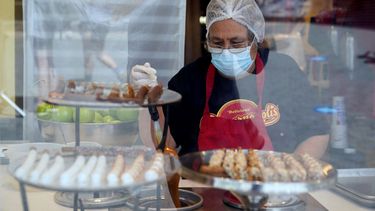 Una empleada trabaja de repostera en un mercado.