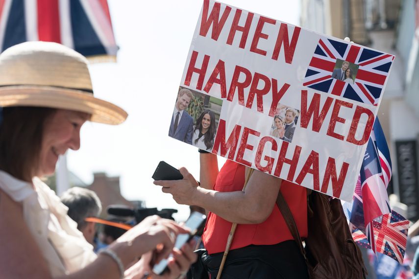 Los espectadores muestran emoción por la boda de Meghan y Harry con pancartas.&nbsp;