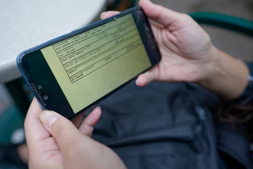 La venezolana Candy Cegarra muestra una foto de un documento en su celular durante una entrevista con The Associated Press, donde la Oficina de Aduanas y Protección Fronteriza de Estados Unidos escribió la dirección de una iglesia en El Paso como su dirección.