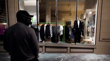 Un hombre permanece frente a un escaparate roto en una tienda durante protestas en Portland, Oregon.&nbsp;