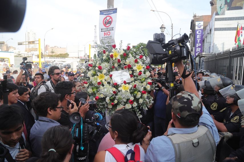 Seguidores del expresidente Alan García llegan con ramos de flores a la sede del Partido Aprista este miércoles en Lima, donde se celebrará el velatorio.