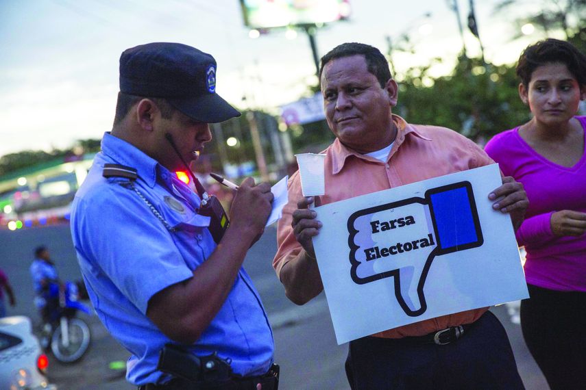 Un policía requisa a un hombre que participa en una protesta en demanda de elecciones libres y transparentes en Managua.&nbsp;