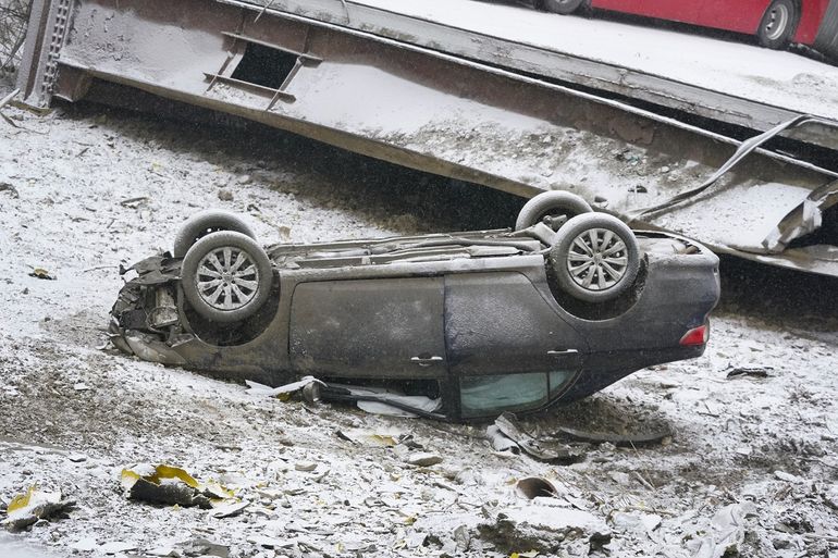 Un automóvil que estaba en un puente cuando colapsó se ve el viernes 28 de enero de 2022 en el East End de Pittsburgh. Cuando el puente se derrumbó, los rescatistas descendieron casi 150 pies mientras otros formaban una cadena humana para ayudar a rescatar a varias personas del autobús que colgaba.  