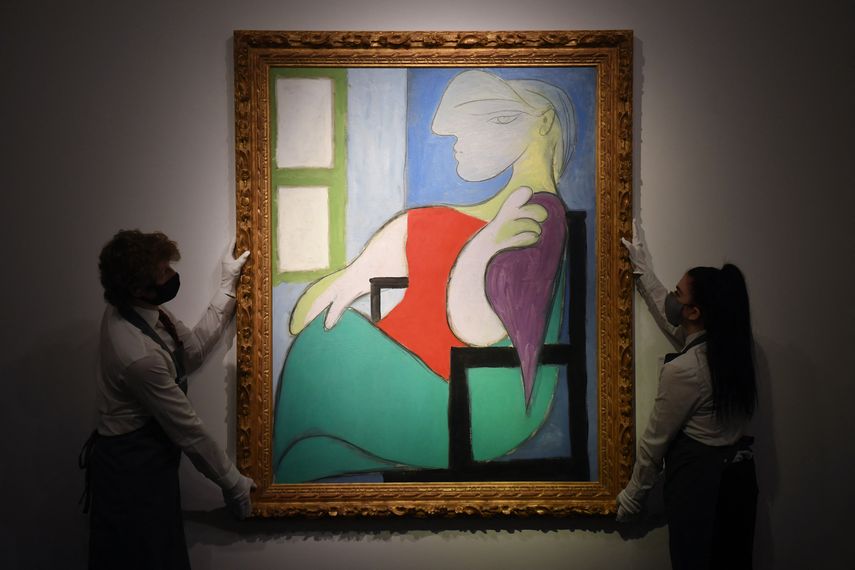 En esta foto de archivo tomada el 22 de abril de 2021, los trabajadores de la galería muestran una obra de arte titulada Femme assise près dune fenêtre (Marie-Thérèse) del pintor español Pablo Picasso durante un photocall en la casa de subastas Christie en el centro de Londres. &nbsp;