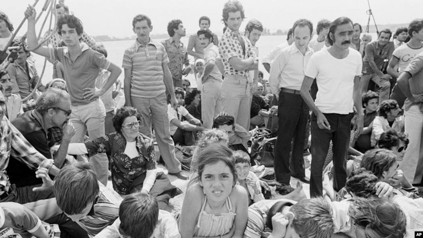 Refugiados cubanos esperan la salida de su bote desde el puerto de Mariel.