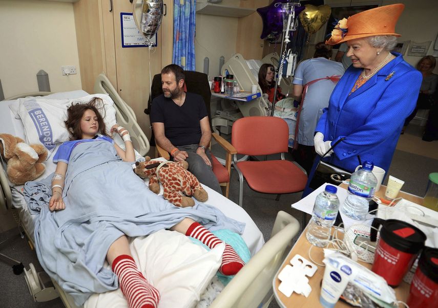 &nbsp;La&nbsp;reina&nbsp;Isabel&nbsp;II de Inglaterra &nbsp;conversa con Evie Mills, de 14 años, y con su padre Craig Mills, durante su visita al Real Hospital Infantil de Manchester (Reino Unido).