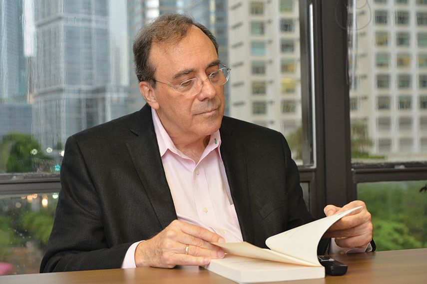 Carlos Alberto Montaner lee una de sus publicaciones durante una visita a la redacción de DIARIO LAS AMÉRICAS. (A. MATA)