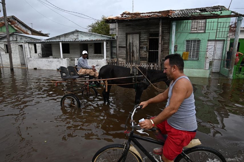 Hombres viajan por una calle inundada tras el paso del huracán Rafel en Batabano, provincia de Mayabeque, Cuba, el 7 de noviembre de 2024. Hombres viajan por una calle inundada tras el paso del huracán Rafel en Batabano, provincia de Mayabeque, Cuba, el 7 de noviembre de 2024.