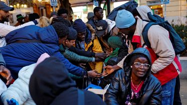 Inmigrantes reciben comida durante el reparto de alimentos durante el Ramadán en la Plaza de Lavapiés de Madrid, el 19 de marzo de 2025.