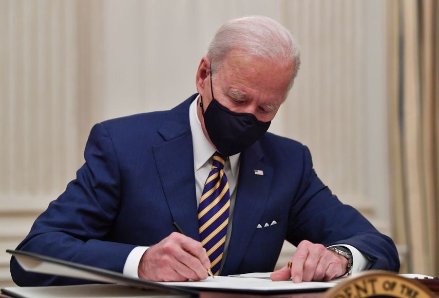 El presidente Joe Biden firma órdenes ejecutivas en la Casa Blanca.