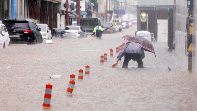 Un hombre avanza por una calle inundada por lluvias torrenciales en Gwangju el 17 de julio de 2025. Al menos tres personas murieron y más de 1000 fueron evacuadas el 17 de julio, después de que Corea del Sur fuera azotada por lluvias torrenciales, según informaron las autoridades. Una región registró la mayor cantidad de lluvia por hora desde que se tienen registros completos.&nbsp;&nbsp;