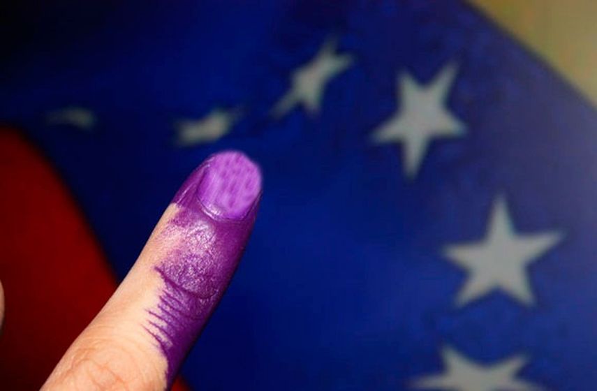 Foto de archivo donde se ve a una venezolana depositar su papeleta de votación en una caja de Consejo Nacional Electoral. (Archivo)