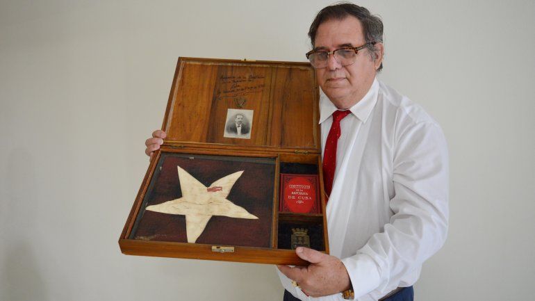 Eduardo Leal Noda sostiene el cofre que guarda la bandera y la copia de la primera constitución de la República de Cuba