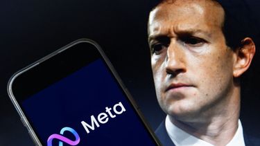 El presidente de Meta Mark Zuckerberg junto al logo de la matriz en un celular.