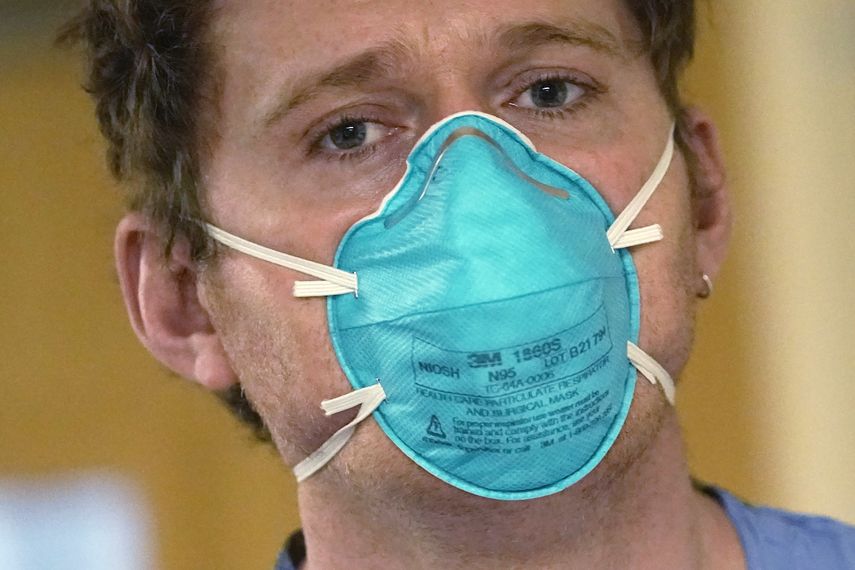 El enfermero Scott McGieson lleva una máscara N95 mientras sale de la habitación de un paciente en la unidad de cuidados intensivos del Centro Médico Harborview, el viernes 14 de enero de 2022, en Seattle.&nbsp;