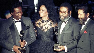 La cantante Diana Ross acompaña a los compositores Lamont Dozier, Brian Holland y Eddie Holland, de izquierda a derecha, luego de que estos fueron incorporados al Salón de la Fama del Rock and Roll el 17 de enero de 1990 en Nueva York.