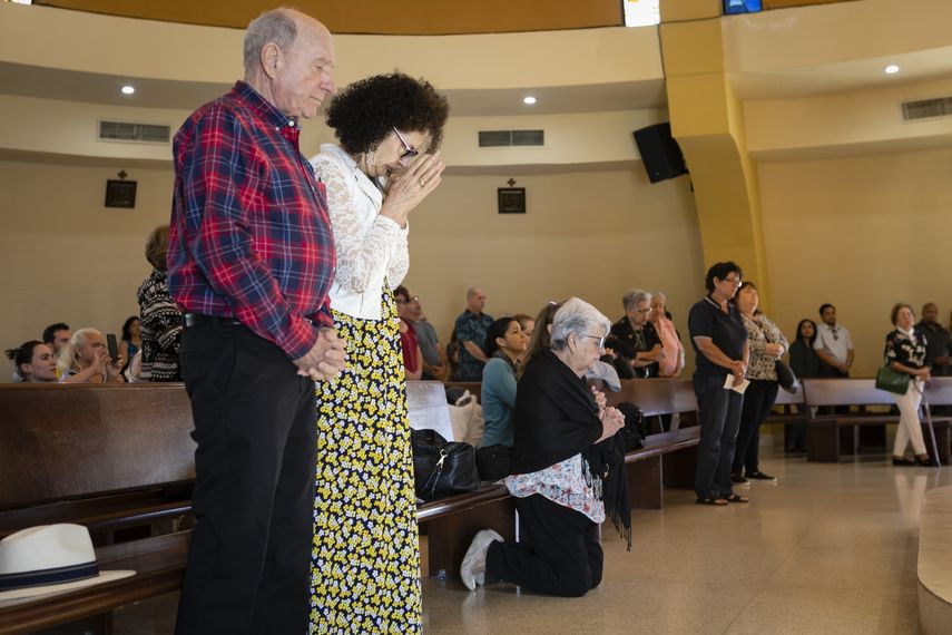 Varias personas imploran a la Virgen de la Caridad en la Ermita en Miami.