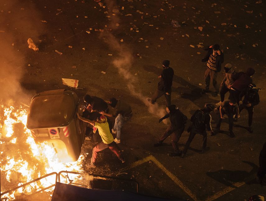 Manifestantes se alejan del gas lacrimógeno arrojado por la policía nacional durante enfrentamientos en Barcelona, España, el viernes 18 de octubre de 2019. 