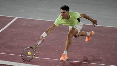 El español Carlos Alcaraz devuelve una pelota al estadounidense Tommy Paul durante un partido de exhibición en la Plaza de Toros de la Ciudad de México, el 29 de noviembre de 2023.
