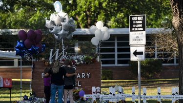 Una familia rinde homenaje frente a las cruces que llevan los nombres de las víctimas en la escuela primaria Robb en Uvalde, Texas, jueves 26 de mayo de 2022.&nbsp;