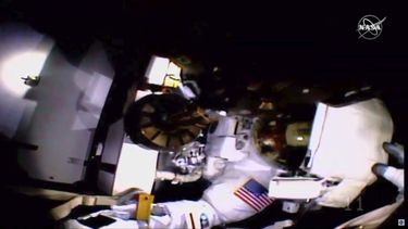 En esta imagen de un video de la NASA, la astronauta Jessica Meir, cuya mano se ve a la derecha, toma el casco de su compa&ntilde;era Christina Koch durante una caminata espacial para reparar la red el&eacute;ctrica de la Estaci&oacute;n Espacial Internacional.&nbsp;