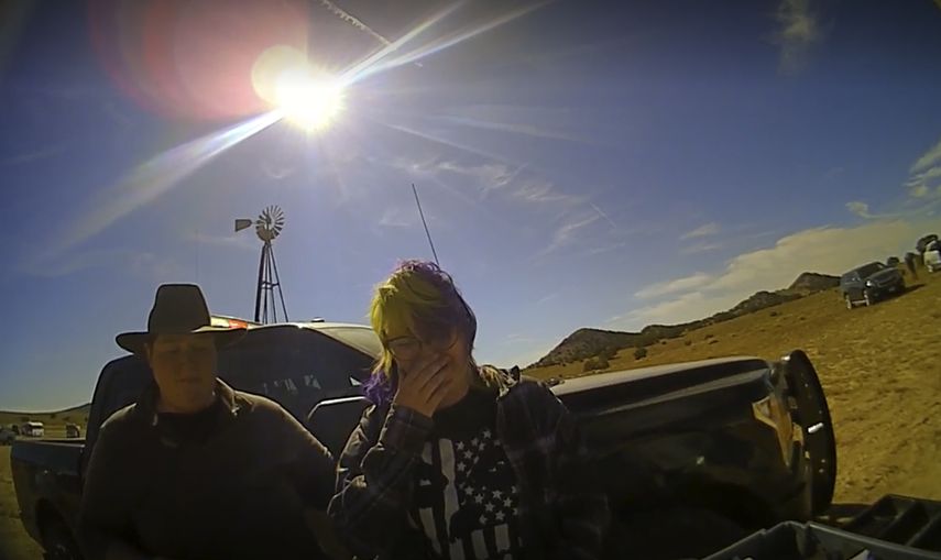 En esta captura de pantalla del video de una cámara de solapa proporcionada por la Oficina del Jefe de Policía del Condado de Santa Fe, la armera de cine Hannah Gutiérrez-Reed, a la derecha, llora al hablar con un asistente del alguacil mientras un colega está junto a ella en el set de la película de vaqueros Rust. Jueza rechaza desestimar cargos contra armera.