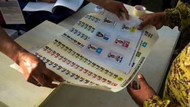 Un soldado recibe una boleta de votación durante las elecciones presidenciales y legislativas en un colegio electoral del barrio Campanera en Soyapango, El Salvador, el 4 de febrero de 2024.