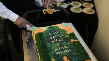 Un mesero corta trozos de un pastel decorado con la portada de la novela En agosto nos vemos para celebrar el natalicio del autor colombiano Gabriel García Márquez y el lanzamiento de su novela póstuma en una librería en la Ciudad de México el miércoles 6 de marzo de 2024.