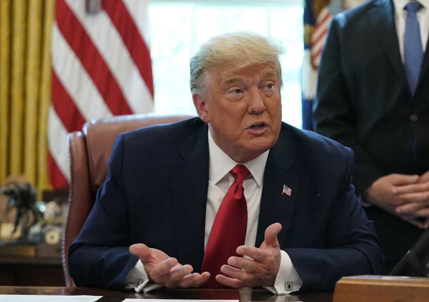 El presidente Donald Trump habla con asesores en la Oficina Oval en la Casa Blanca.