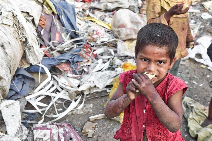 Foto de archivo de un niño comindo restos de basura. &nbsp;