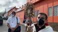 El obispo de la Diócesis de Matagalpa, monseñor Rolando Álvarez, carga en sus manos la imagen del Santísimo luego que la policía le impidió por varias horas el acceso a la curia y la residencia episcopal, en la ciudad de Matagalpa, en el norte de Nicaragua. Atrás se observan patrullas policiales y dos agentes armados con fusiles custodiando el acceso a la curia.