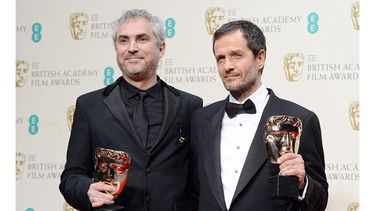 El director mexicano Alfonso Cuarón y el productor británico David Heyman posan para la prensa tras recibir los premios por la película. (EFE)