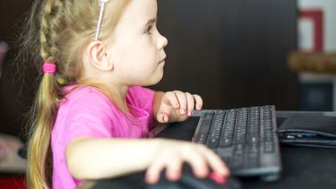 Una niña utiliza una computadora.&nbsp; El peligro de internet para los menores.