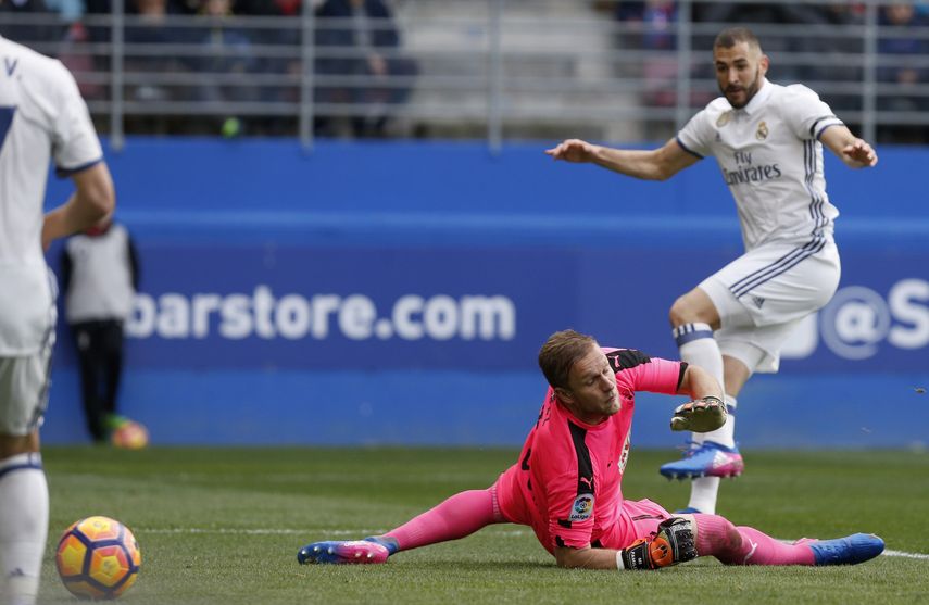 El delantero francés del&nbsp;Real&nbsp;Madrid, Karim Benzema (derecha), supera al portero del Eibar, Yoel Rodríguez, para marcar uno de los dos goles que logró en el juego.&nbsp;