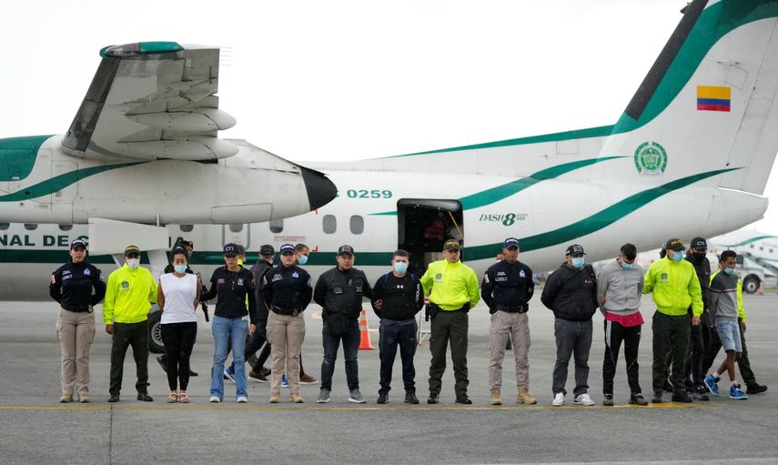 La policía presenta a los medios de comunicación a cinco personas acusadas del asesinato del fiscal de Paraguay para casos de crimen organizado y narcotráfico, Marcelo Pecci, en la pista de un aeropuerto en Bogotá, Colombia, el miércoles 8 de junio de 2022.