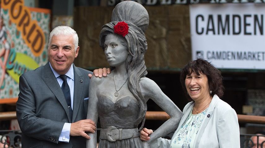 Mitch Winehouse y Janis Winehouse posan junto a la estatua de su hija, la fallecida cantante Amy Winehouse. (AP)