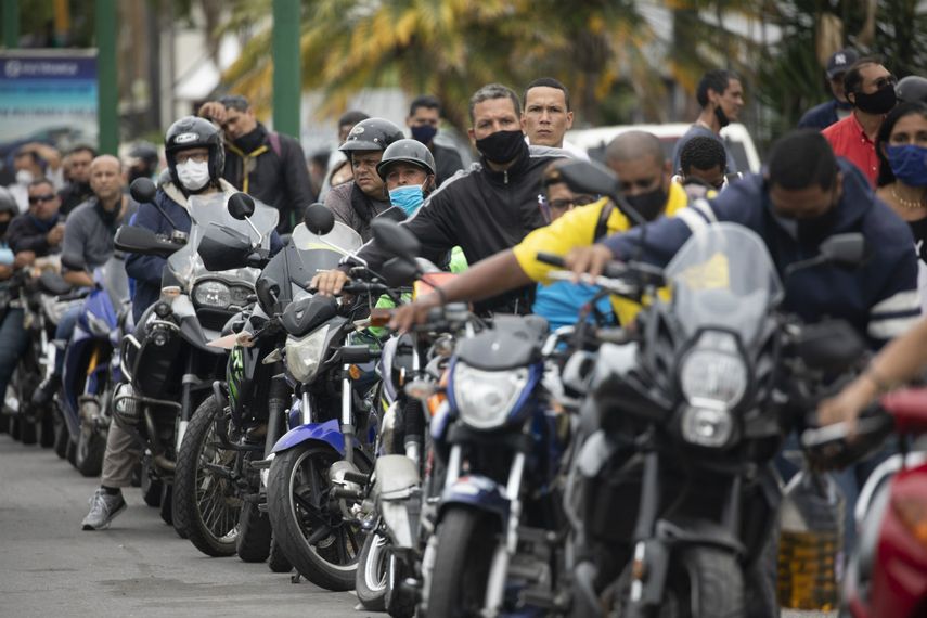 Motociclistas portan mascarillas mientras esperan su turno para cargar gasolina en Caracas (Venezuela), el martes 8 de septiembre de 2020.