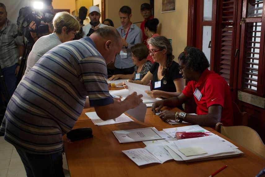 Dos personas se registran en uno de los colegios electorales antes de votar en el referendo sobre la nueva Constitución, en La Habana (Cuba).