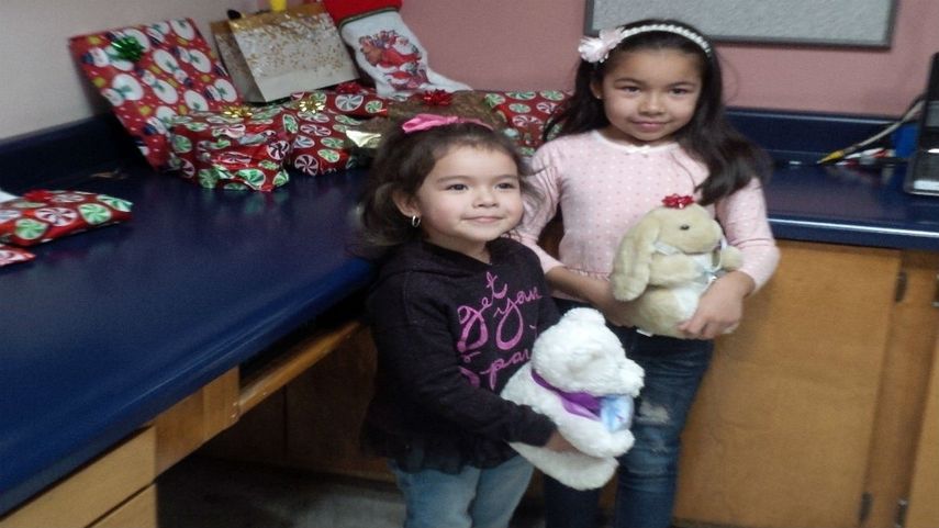 Dayami de 8 años, junto a su hermana Ximena de 4, años sosteniendo en la cocina de su casa en México los regalos que les trajo de Estados Unidos Randy Heiss.