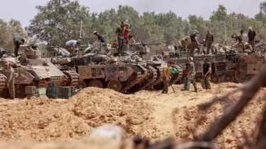Las tropas israelíes trabajan en sus vehículos blindados en una posición cerca de la frontera de Israel con la Franja de Gaza el 18 de mayo de 2025.