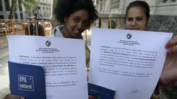 Dos cubanas muestran la constancia de la Cancillería de Uruguay.