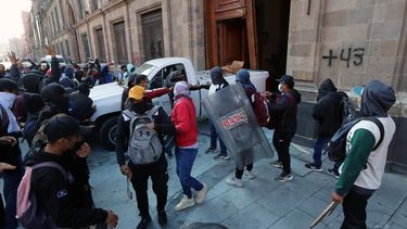 Estudiantes se manifiestan después de derribar la puerta del palacio presidencial en la Ciudad de México el 6 de marzo de 2024, durante una protesta por la desaparición de los 43 estudiantes de la escuela de formación docente de Ayotzinapa en 2014.