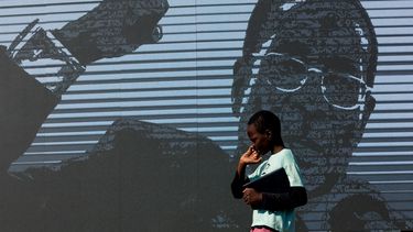Un niño pasa junto a una imagen digital del expresidente zimbabuense Robert Mugabe mientras su cuerpo yace en el cementerio Murombedzi Growth Point, a unos 107 km al noroeste de Harare, Zimbabue, el 16 de septiembre de 2019.&nbsp;