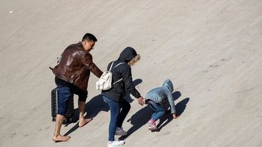 Una familia de migrantes sube por la orilla norte del río Bravo (Grande) después de cruzar desde Ciudad Juárez, México, el miércoles 21 de diciembre de 2022, en su intento por entrar a El Paso, Texas.