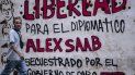 Un hombre pasa junto a un grafiti que dice Libertad para el diplomático Alex Saab, secuestrado por el gobierno de Cabo Verde en Caracas, el 23 de febrero de 2021. Un hombre pasa junto a un grafiti que dice Libertad para el diplomático Alex Saab, secuestrado por el gobierno de Cabo Verde en Caracas, el 23 de febrero de 2021.