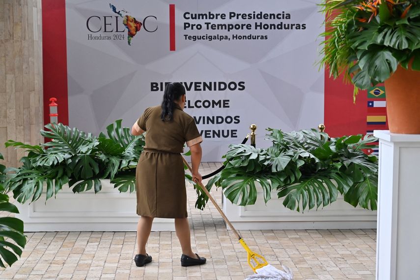 Una empleada limpia el suelo a la entrada del Banco Central de Honduras (BCH), sede de la IX Cumbre de la Comunidad de Estados Latinoamericanos y Caribeños (CELAC), en Tegucigalpa, el 8 de abril de 2025.&nbsp;